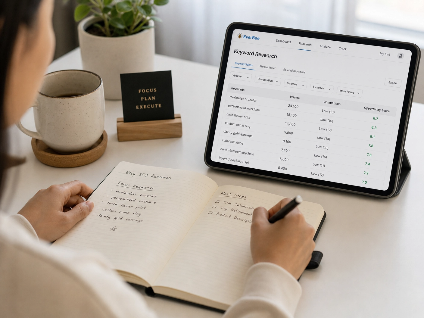 Asian entrepreneur taking notes while viewing high-volume, low-competition keywords on an Etsy SEO tool.