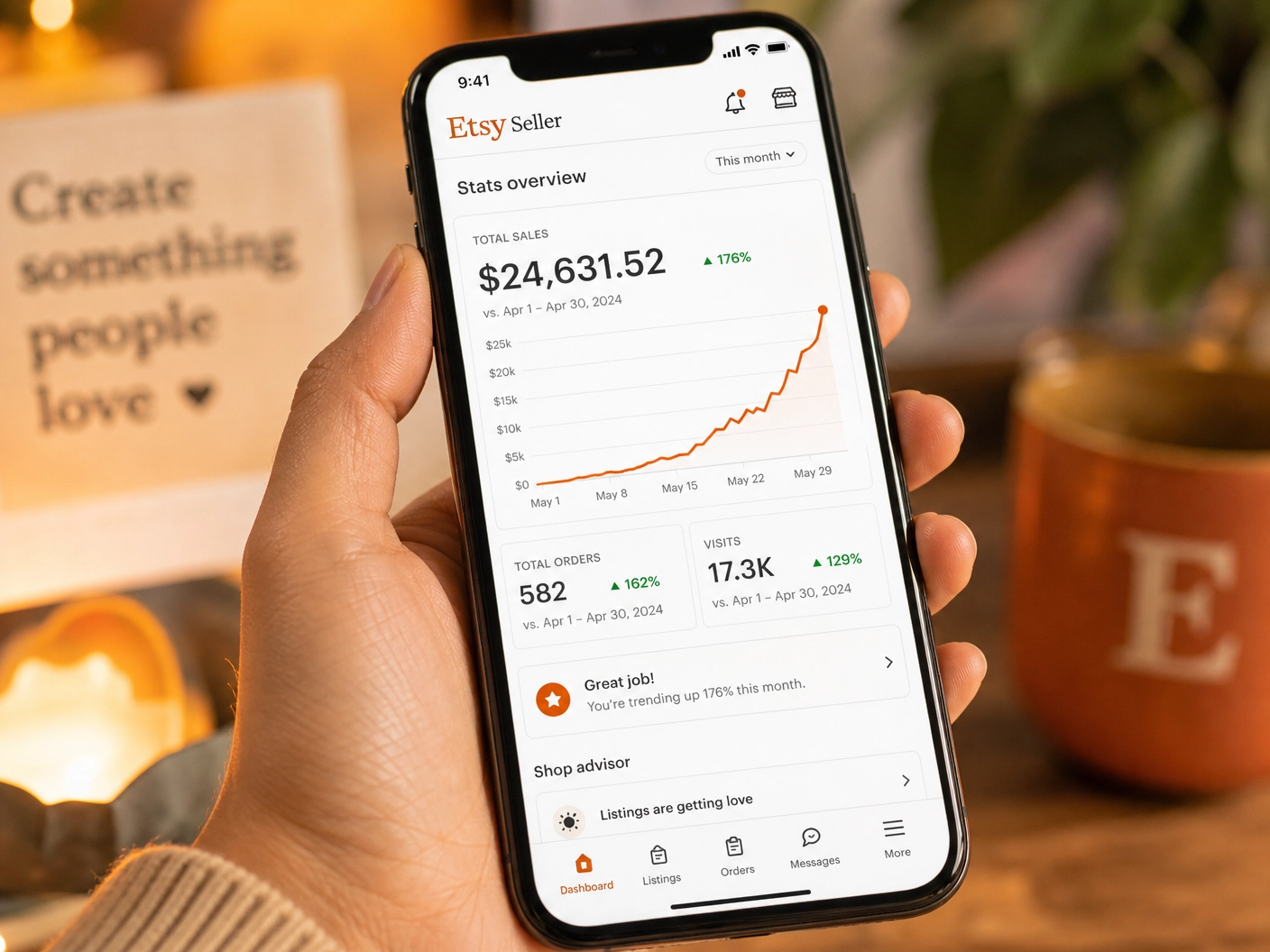 Smartphone displaying a rapidly climbing sales chart on the Etsy seller app, held by an Asian hand.